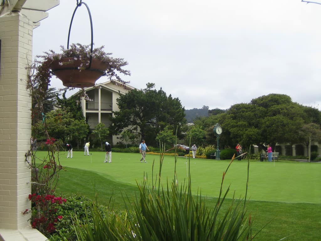 Practice putting green with players getting ready for a tournament at Pebble Beach Golf Links