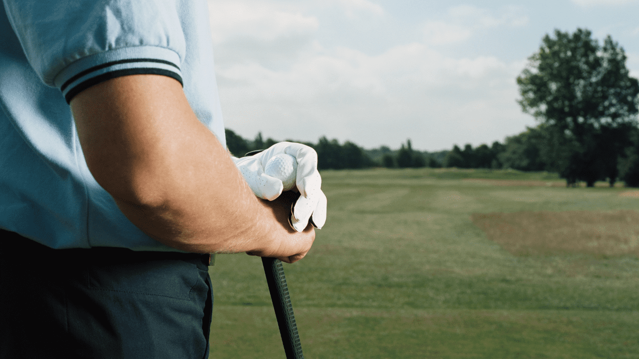 male golfer showing his arms crossed as he looks over the course, the mental game of golf.
