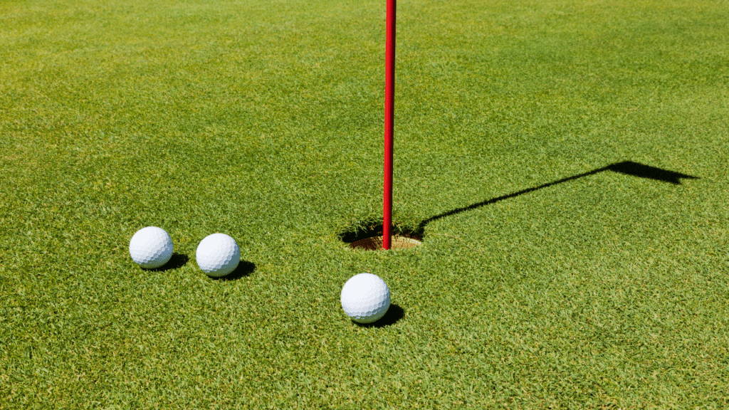 Three Golf Balls around a pin and hole 