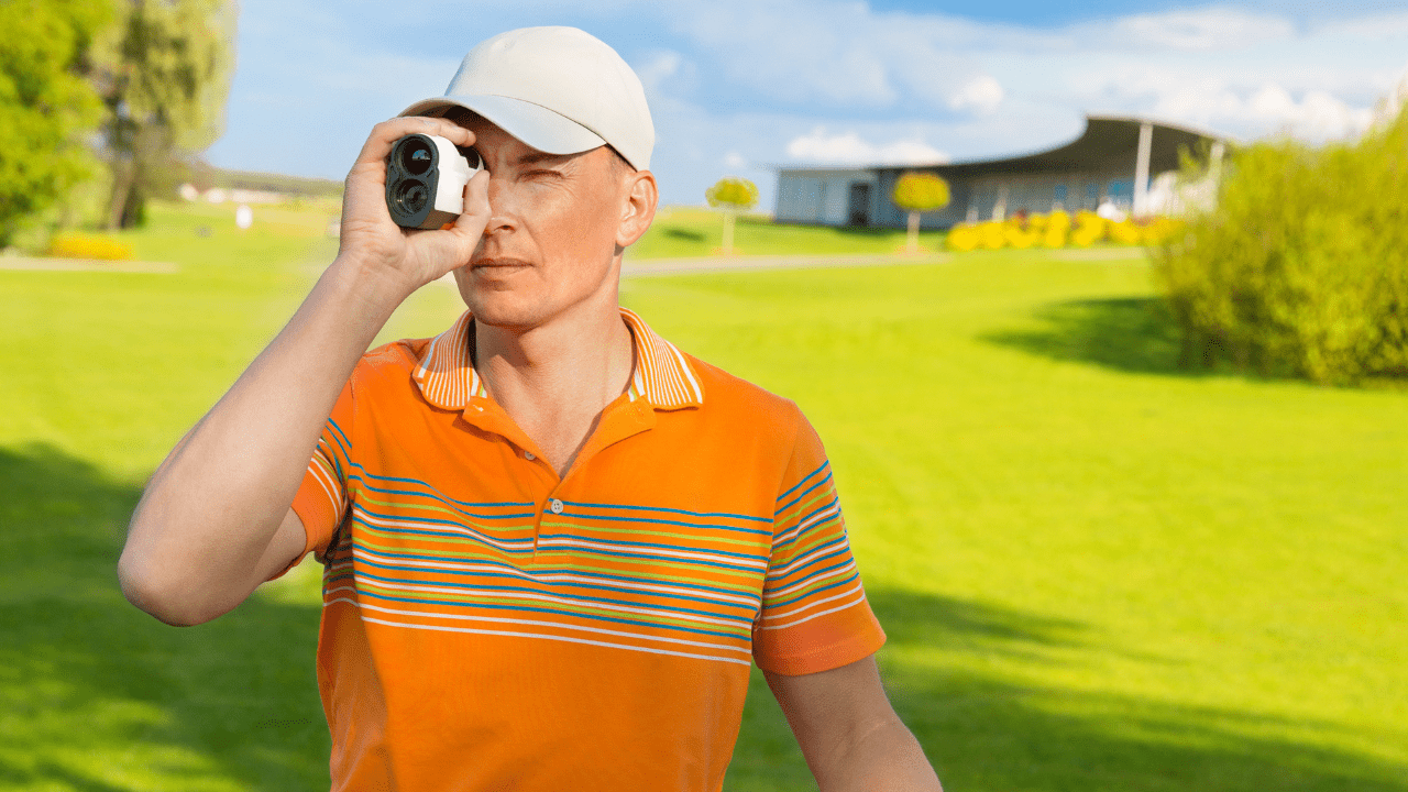 man in orange shirt looking through his golf rangefinder
