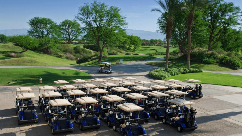 Photo of multiple golf carts parked near golf course pro shop.