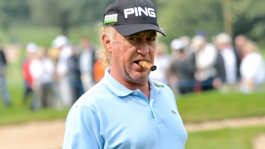 Close up photo of Miguel Angel Jimenez smoking his cigar on the golf course.