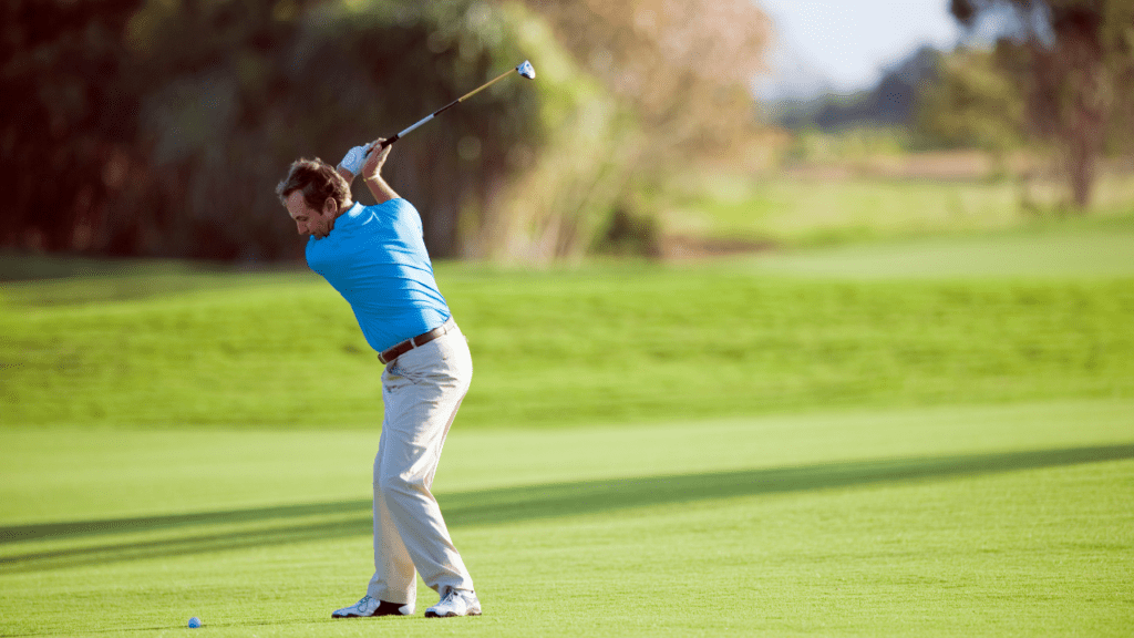 Golfer hitting his fairway shot with a fairway golf club.