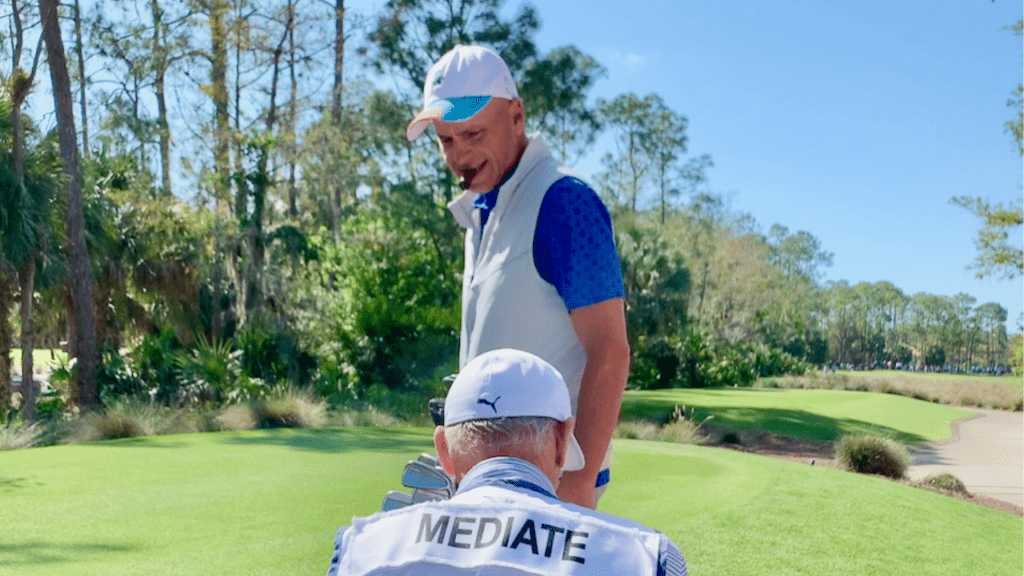 Rocco Mediate on hole 17 at the Tiburon Golf Club in Naples, Florida.  Close up photo of him and his caddy; while smoking a cigar.