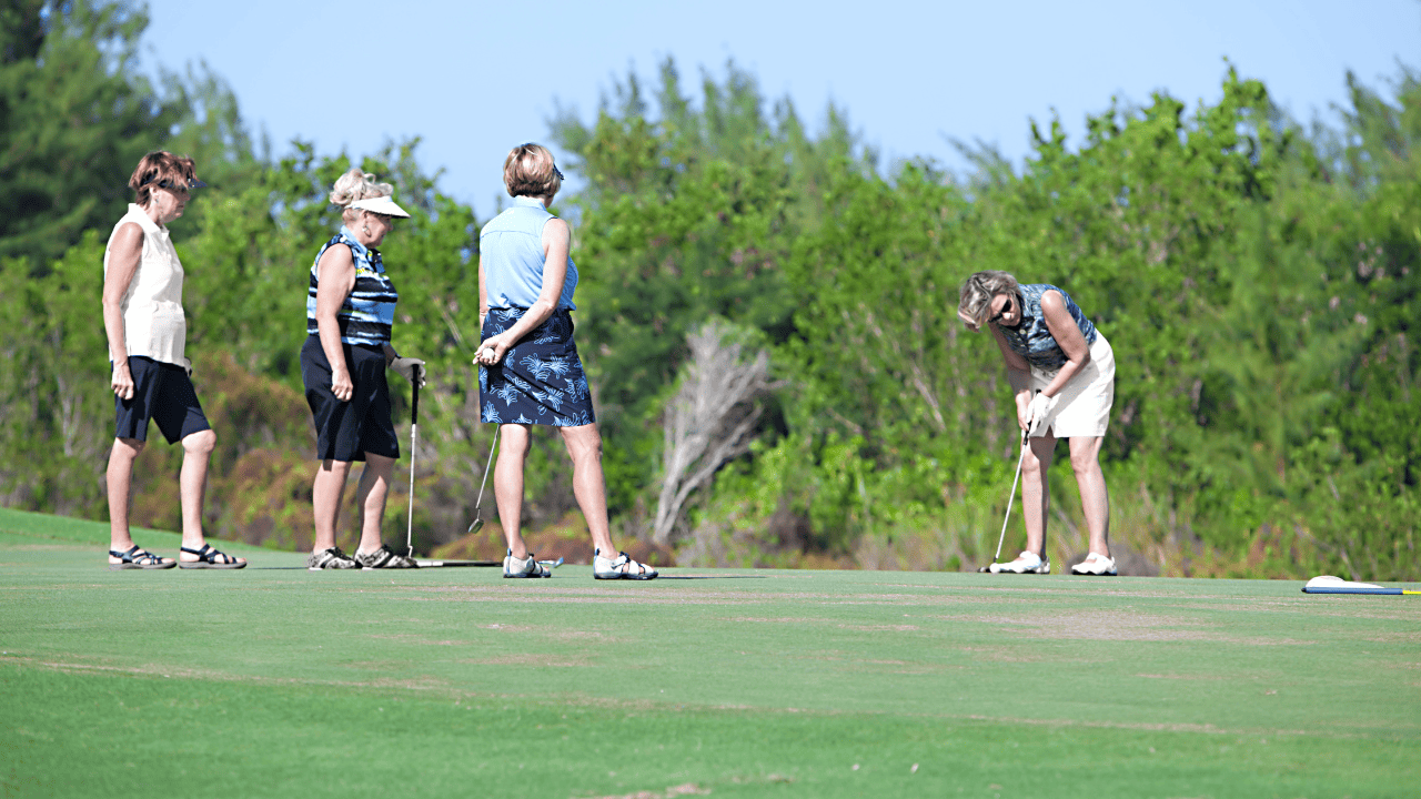 senior ladies golfing and chatting together on the green. Types of golf games shown is a sramble.