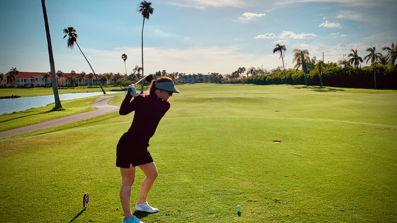 Erin hitting a men's golf club as a taller woman golfer with faster swing speeds.