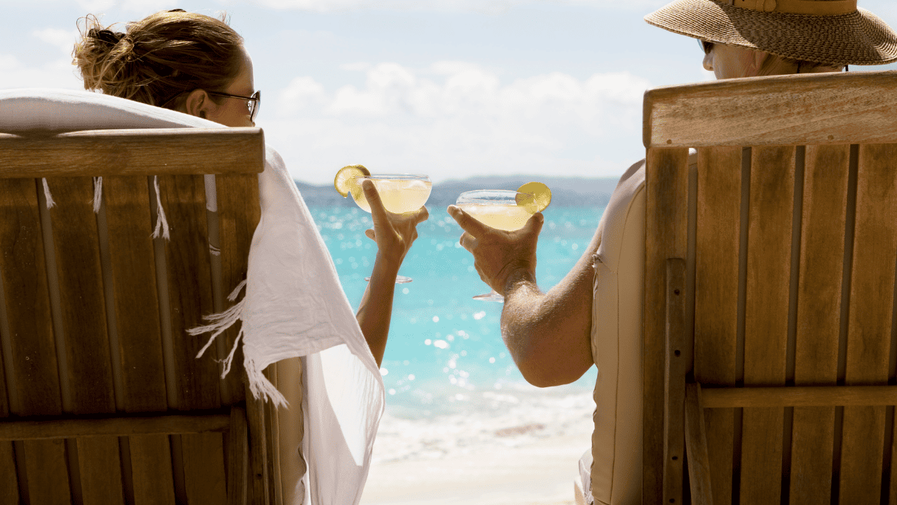 Couple toasting with margaritas at the beach
